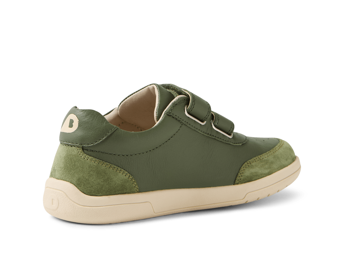 Green children's shoe with velcro straps on a white background