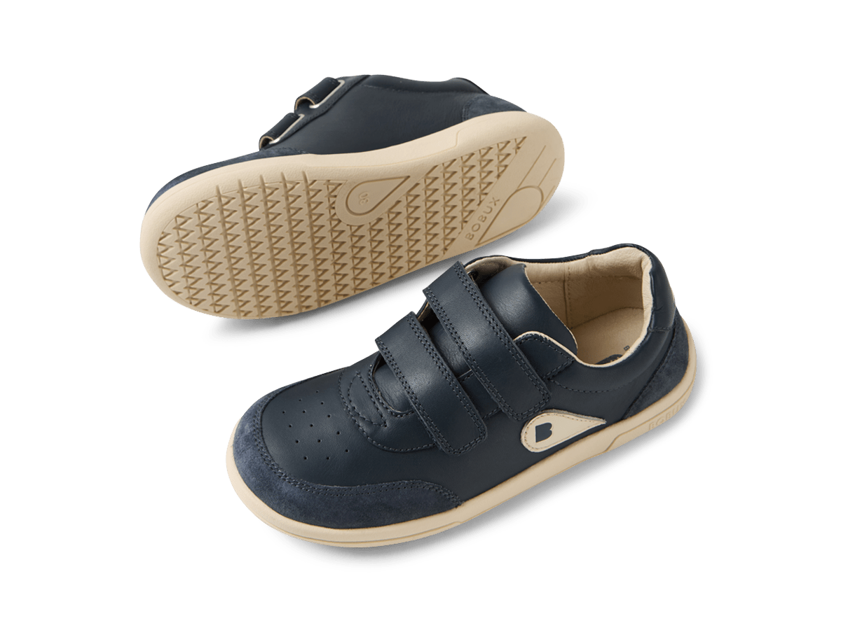 Pair of navy blue children's shoes with beige soles on a white background