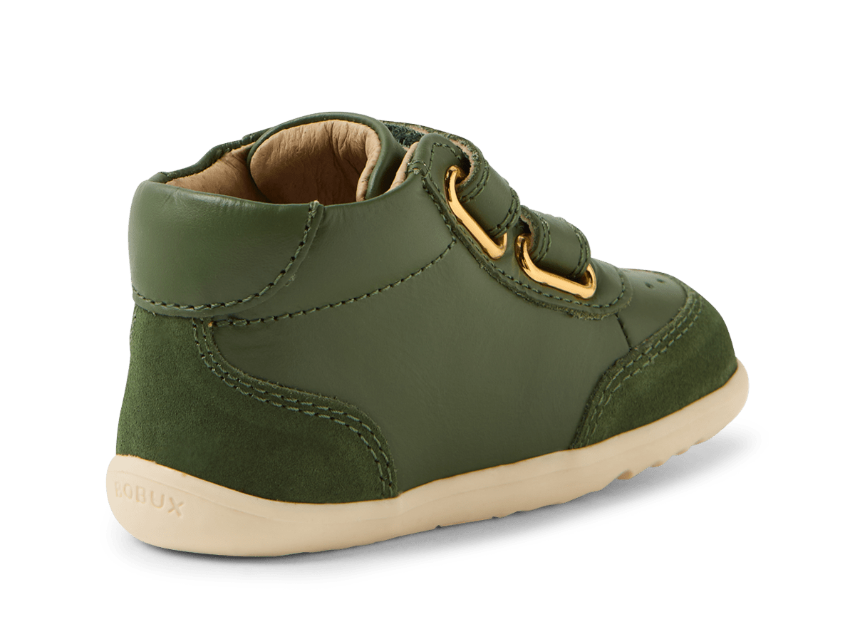 Green children's shoe with gold buckle on a white background