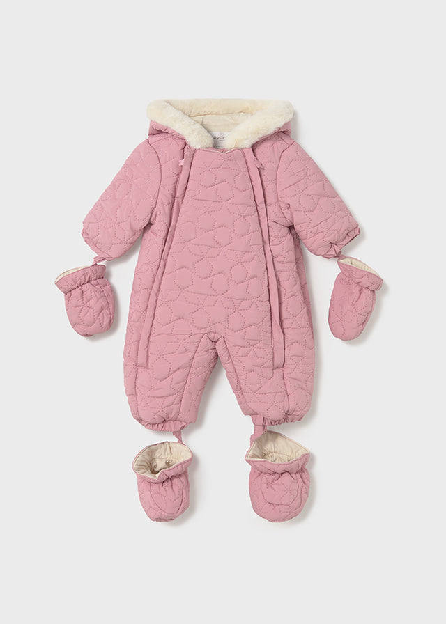 Pink baby snowsuit with matching mittens and booties on a light pink background