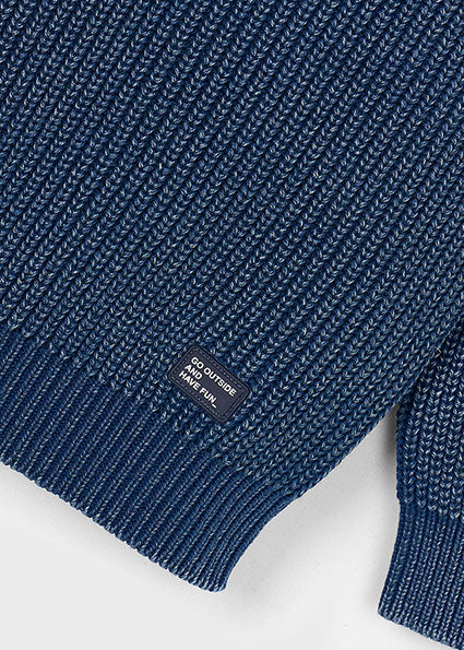 Close-up of a blue knitted sweater with a brand label on a white background