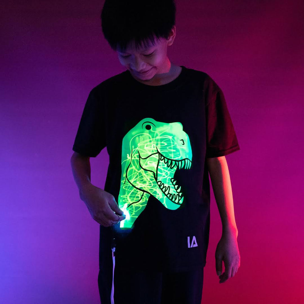 
            
                Load image into Gallery viewer, Illuminated apparel - glow in the dark interactive t-shirt dinosaur design
            
        