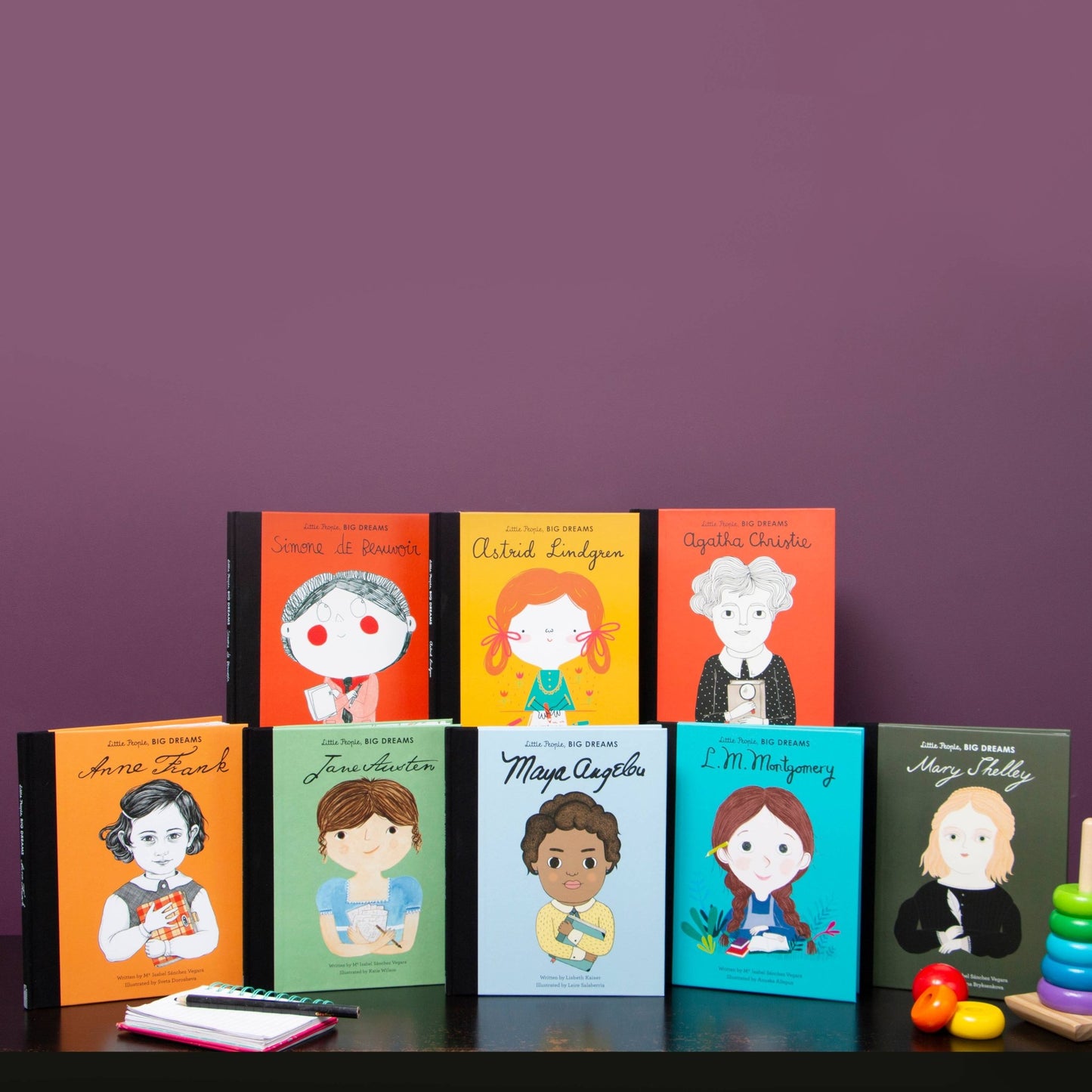 Collection of books with illustrated covers featuring famous women on a purple background