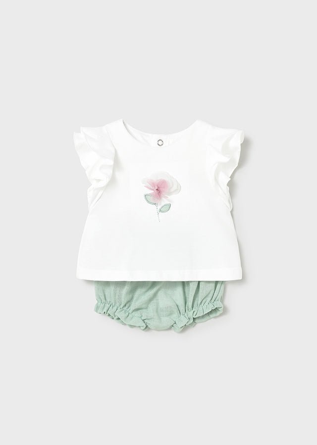 Baby white ruffle‑sleeve top with floral detail and mint green bloomer shorts.