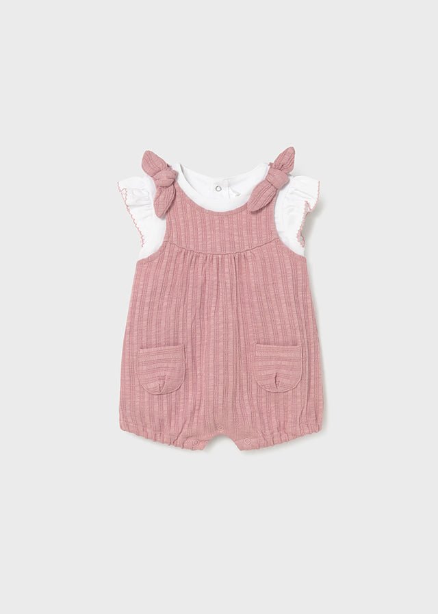 Pink ribbed baby romper with bow straps, pockets, and white ruffle‑sleeve tee.

