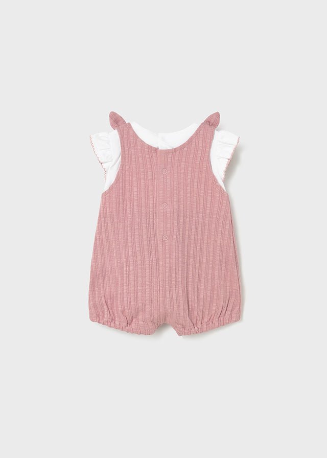 Pink ribbed baby romper with bow straps, pockets, and white ruffle‑sleeve tee.

