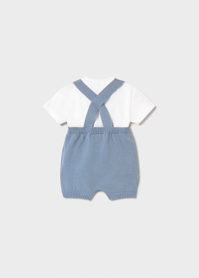 Baby blue knitted romper with shoulder straps and white short‑sleeve t-shirt.
