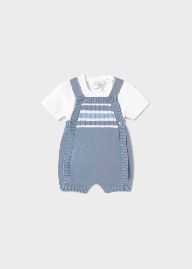 Baby blue knitted romper with shoulder straps and white short‑sleeve t-shirt.