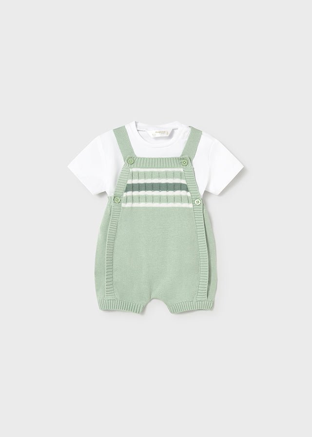 Baby green knitted romper with shoulder straps and white short‑sleeve t-shirt.