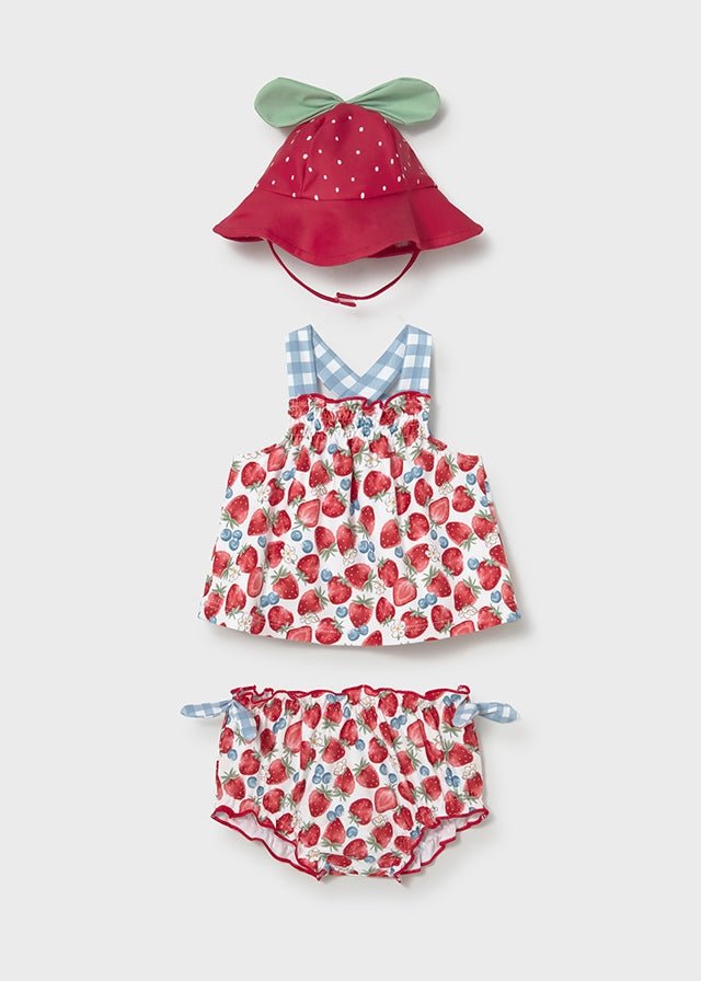 Strawberry‑print baby girl swimsuit with gingham straps, bloomers, and matching berry hat.

