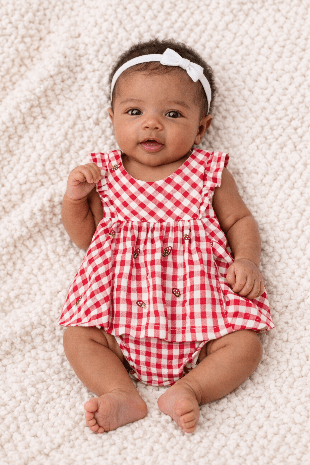 Red gingham baby dress with ruffled sleeves, embroidered strawberries, and matching bloomers.
