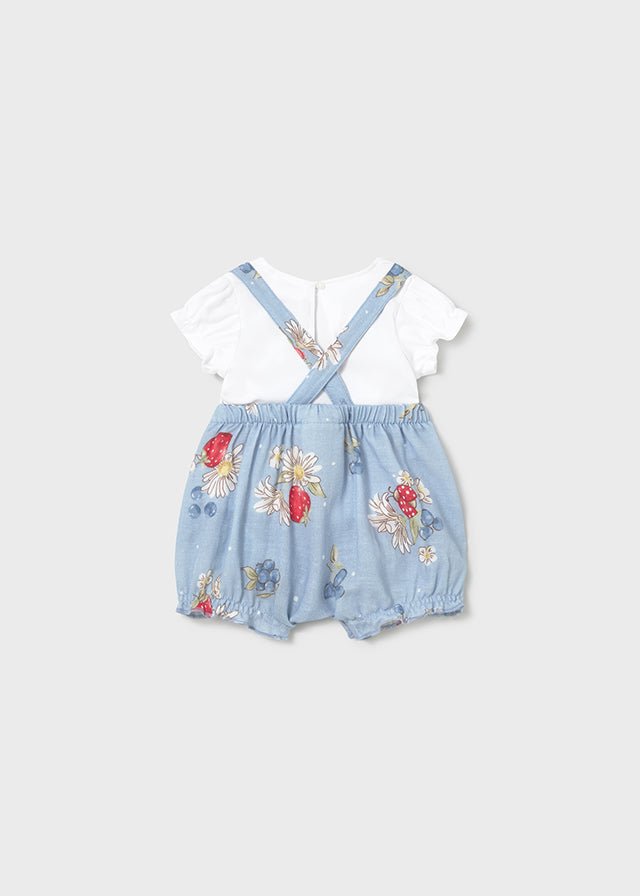 Baby romper featuring berries and daisies on blue fabric with button‑front design. with white ruffle sleeve t-shirt.