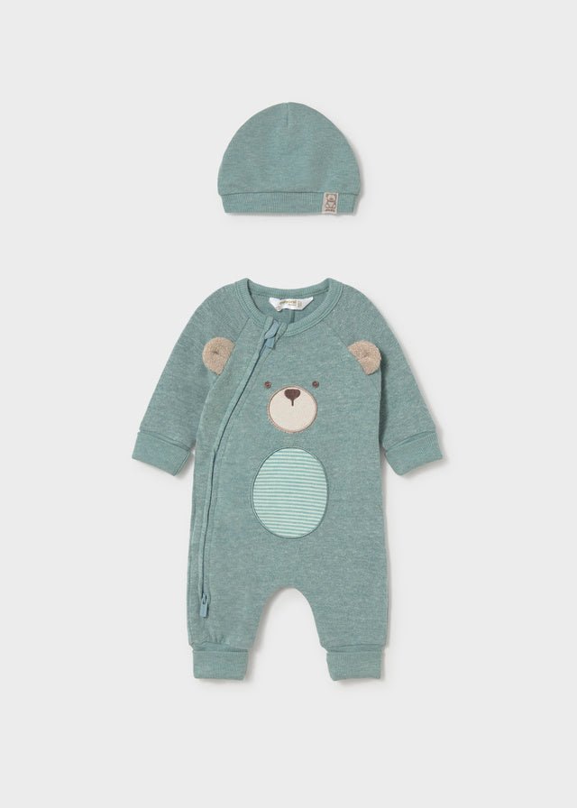 Green baby romper with bear design and matching hat on a light gray background