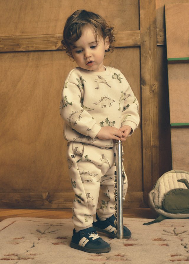 Light Taupe baby trousers with a subtle dinosaur print and long‑leg design.