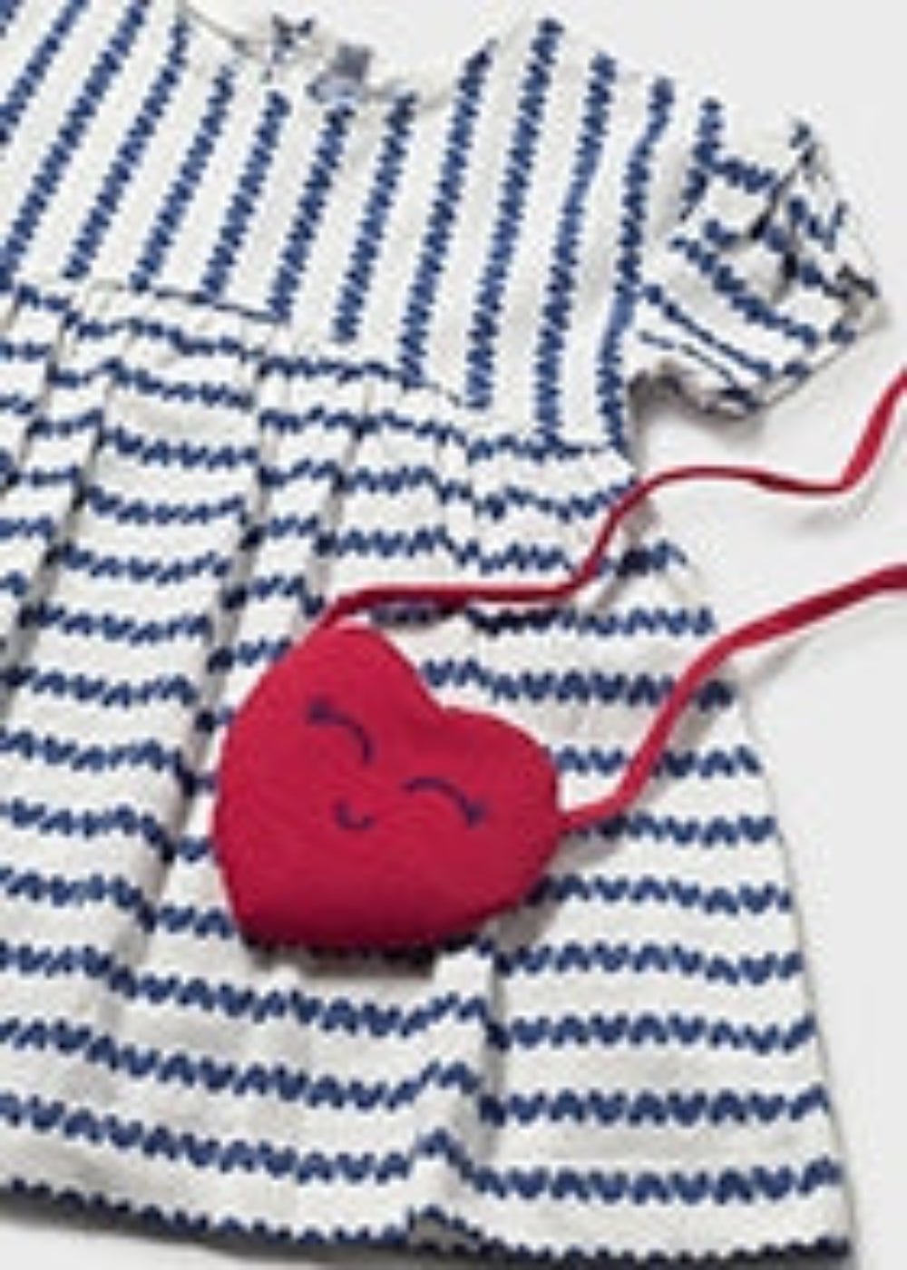 Blue and white striped dress with a red heart-shaped bag on a white background