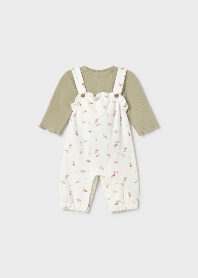 Children's outfit with floral overalls and green shirt on a white background