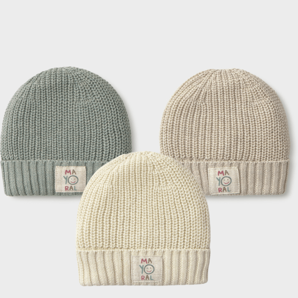 Three ribbed knit beanie hats in different colors: sage green, cream, and light beige, arranged on a light gray background. Each hat has a small rectangular brand patch on the cuff reading 'MA YO RAL'.