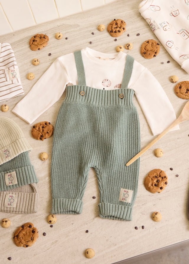 Mayoral baby knit suspenders pants in green — soft cotton trousers with cross‑over straps and button detail.