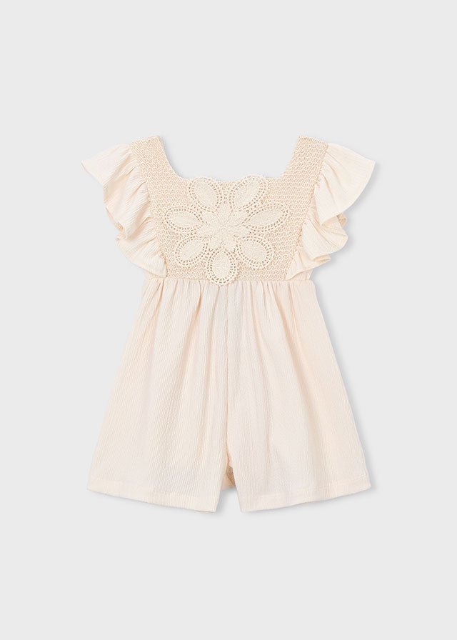 Girls’ cream romper with ruffled shoulders and crochet floral front panel, lightweight and summery.