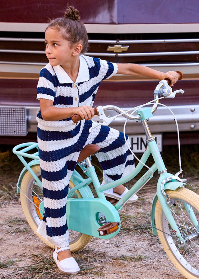 Girls’ two‑piece nautical knit set with navy and white stripes, scalloped texture, white collar, gold buttons, and matching trousers.