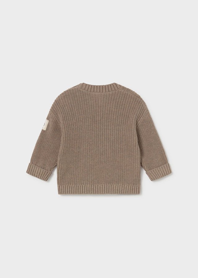 A ribbed knit long-sleeve sweater shown from the back, in a taupe-brown color, on a light gray background.
