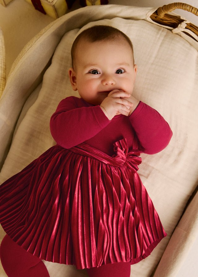 Red baby romper with pleated skirt detail and bow, Style 16‑02813‑019.