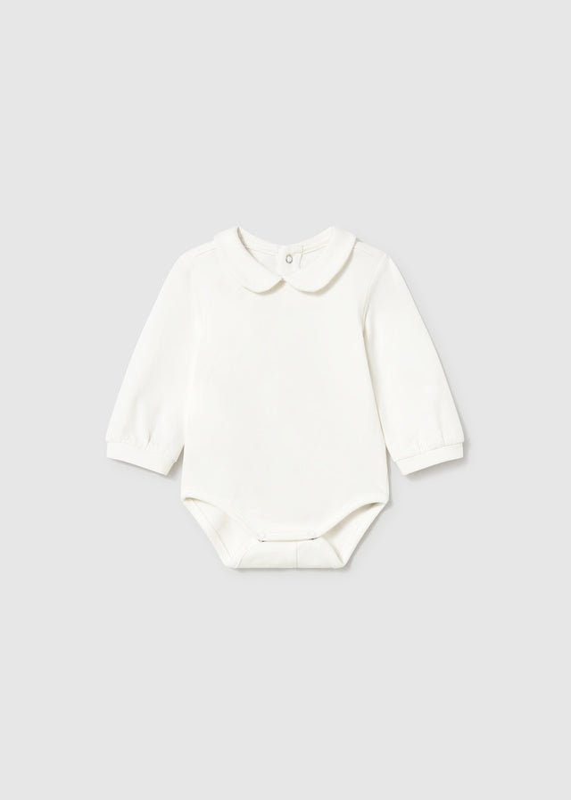 A long-sleeve baby bodysuit in off-white with a Peter Pan collar, laid flat against a light gray background.