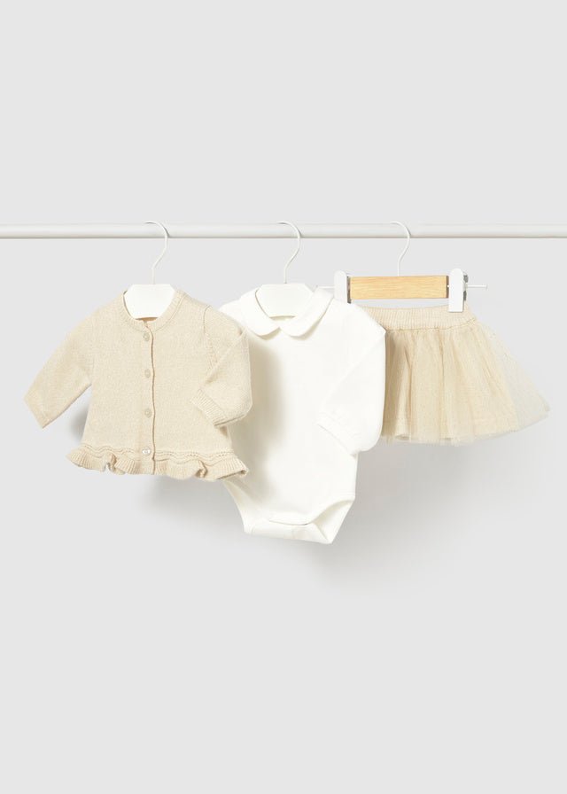 Baby outfit set with jacket, shirt, and skirt on a white background