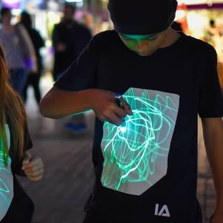 
            
                Load image into Gallery viewer, Illuminated apparel - Glow in the dark interactive t-shirt
            
        