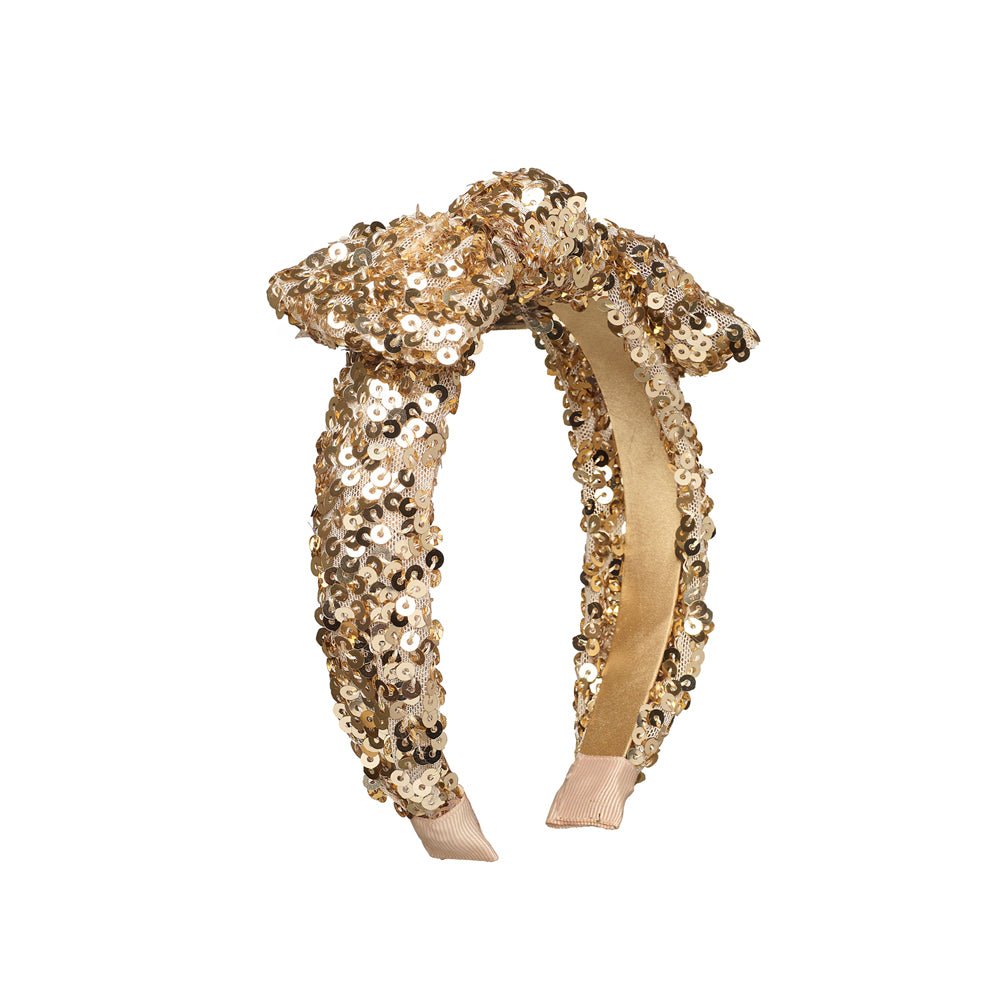 A gold sequined headband with a large bow on top, shown against a plain white background.