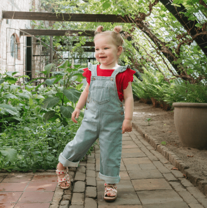 Shoesme extemeflex Soft micro‑leather first‑walker sandals in pink with cheerful strawberry design. modelled on a young girl.